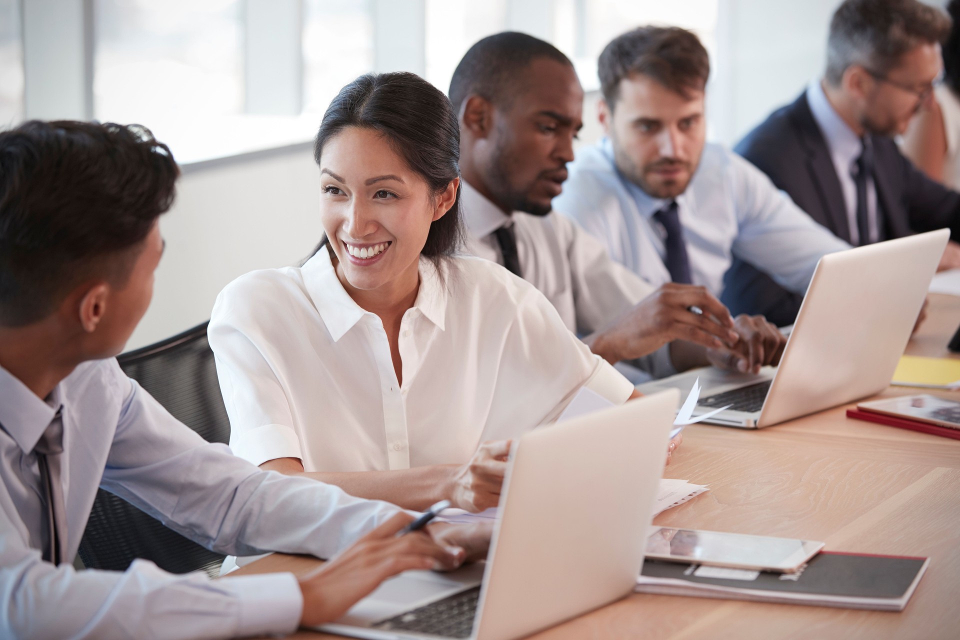 Group Of Businesspeople Meeting Around Table In Boardroom